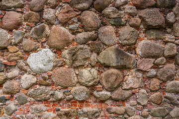 Fototapeta na wymiar An old wall of bricks and stones. Background