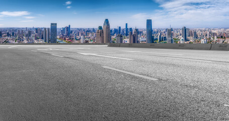 Panoramic skyline and empty asphalt road with modern buildings
