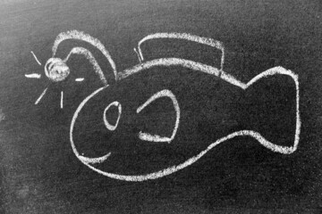 White color chalk hand drawing in angler fish or lantern fish shape on black board background