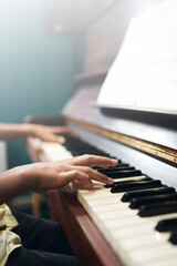 Boy's fingers on piano keyboard