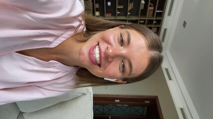 Vertical mobile cam view cute smiling young lady student in wireless headset hold phone shoot self video for social media chat by videocall. Teen female vlogger influencer stream online on web channel - Powered by Adobe