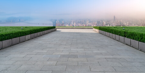 Panoramic skyline and empty square floor tiles with modern buildings