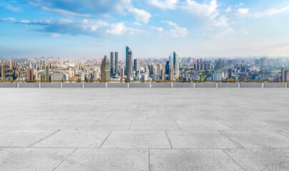 Panoramic skyline and empty square floor tiles with modern buildings