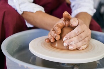 Fototapeta na wymiar closeup female hands twist clay on a potter's wheel