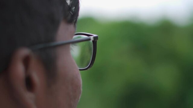 Closeup shot of Indian kid wearing glasses. Smart kid wearing glasses looking sideways.