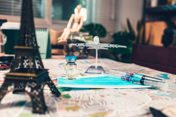 Vaccine, syringe and mask on map. Important equipment before traveling during COVID concept.