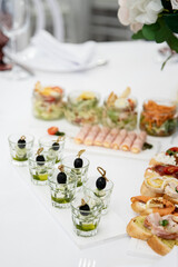 Wedding catering table in powdery pink color. Different food appetizers and snacks