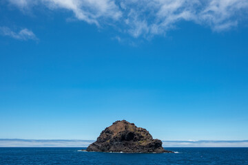 Fototapeta na wymiar Roque de Garachico emerging from the Atlantic Ocean nearby Garachico town, Tenerife, Canary Islands, Spain, small uninhabited islet also known as roque located 300 m off the north coast of the island