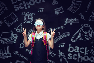 Schoolgirl in fun in medical mask on eyes gesturing V signs. Virus protection. Victory for Covid-19 