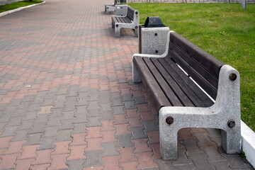 Street wooden benches with a marble base have been standing since Soviet times on a cobbled...
