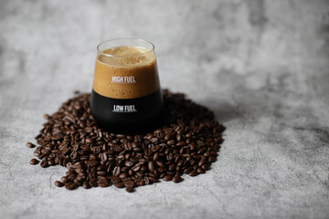 Spray of dark beer with foam in glass with low fuel and high fuel on coffee beans.