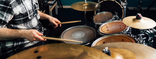 The drummer knocks on the drum set. - obrazy, fototapety, plakaty