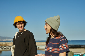 Two jaunty young people strolling along the beach