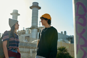 Two spellbound young people standing by a fence