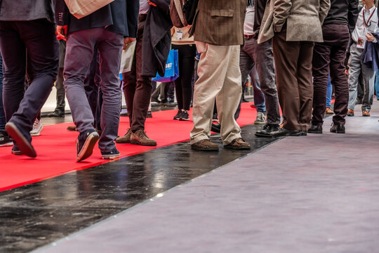 Low section of businessman and woman's legs walking on red carpet