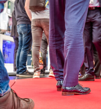 Low section of businessman and woman's legs walking on red carpet