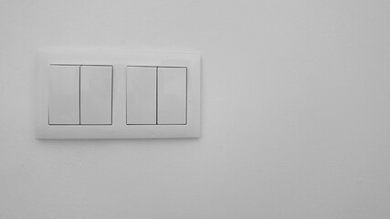 Two white two-button light switch boxes on a white wall. Minimalist image. Essentials of a house.