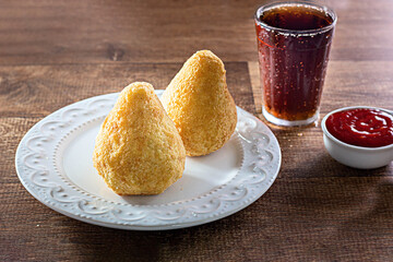 Coxinha - Typical Brazilian Snack with ketchup on a wooden table