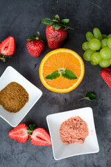 Various fruits and berries on dark stone table, vegan food in the kitchen