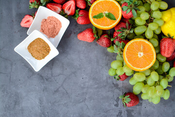 Various fruits and berries on dark stone table, vegan food in the kitchen