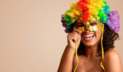 Mooie vrouw gekleed voor carnaval nacht. Glimlachende vrouw klaar om te genieten van het carnaval met een kleurrijke pruik en masker
