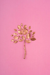 Gold tree on the pink background. Creative composition.