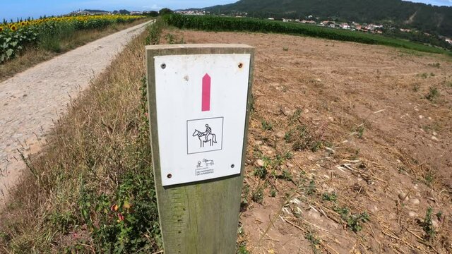 Carreco, Portugal, August 2, 2021: SLOW MOTION SHOT - Wooden signpost on a rural road with a directional sign to the Paths of Mankind and the Garrano in Viana do Castelo, Portugal