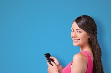 Young lady using a phone with positive expression, smiles broadly
