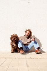 dog and man sitting together in a relaxed and carefree attitude,