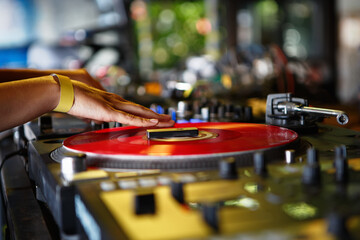 Dj girl playing music on party. Disc jockey scratches vinyl record on turntable on stage