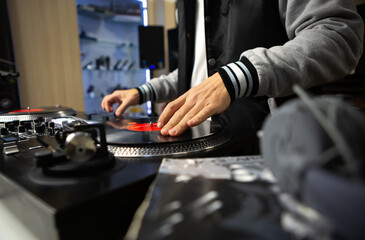 Hip hop dj scratching vinyl record on turn table. Professional disc jockey scratches musical tracks...