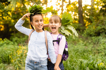 Obraz premium Two cute smiling 8 years old girls posing together in a park on a sunny autumn day. Friendship concept.
