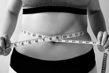 measure the waist with a measuring tape, black and white snapshot, the concept of an ideal figure,...