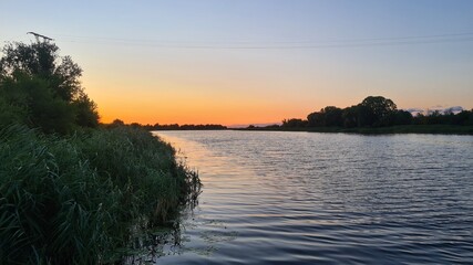 evening on the river with a beautiful sunset and green reeds