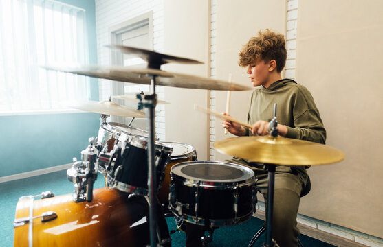 Young teen boy practicing drumming. Drum music school.