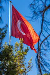 Flag of Turkey waving against a blue sky background.