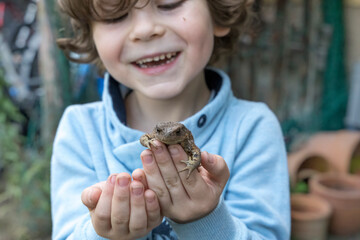 A little boy is happy to have a toad in his hand