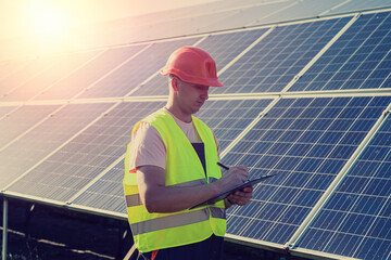 young caucasian man in uniform works at a solar station