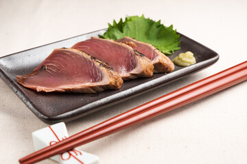 黒い皿に盛りつけられた鰹の刺身