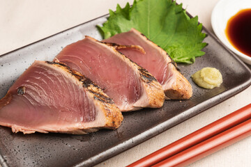 黒い皿に盛りつけられた鰹の刺身