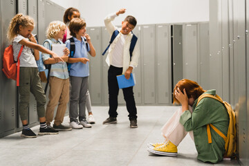 Angry cruel teenagers laughing at their classmate. Elementary school age bullying at school. Social inequality problem. Schoolchildren baiting - obrazy, fototapety, plakaty