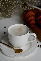 cup of coffee with milk and croissants in the breakfast