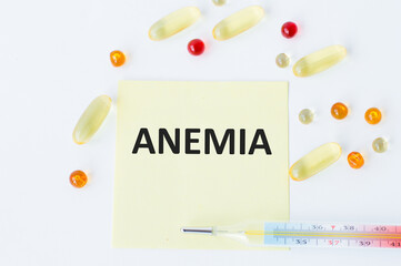 On the card is the text of ANEMIA next to scattered pills and a thermometer