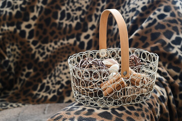 a decorative basket with abstract objects stands on a chair