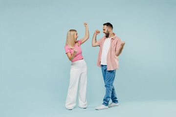 Naklejka premium Full size young exultant couple two friends family man woman in casual clothes do winner gesture together isolated on pastel plain light blue color background studio portrait People lifestyle concept.