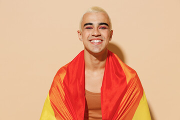 Young smiling happy positive blond latin gay man with make up in beige tank shirt wrapped in...