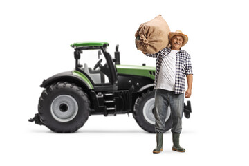 Full length portrait of a farmer carrying a sack and standing in front of a tractor