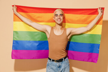 Young activist carefree smiling happy fun cool blond latin gay man 20s with make up in beige tank...