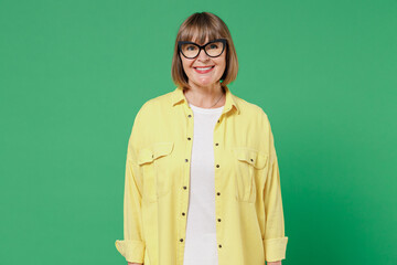 Elderly smiling happy cheerful smart caucasian woman 50s wearing glasses yellow shirt white t-shirt...
