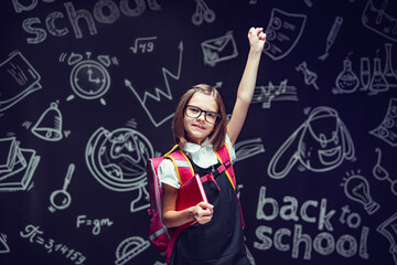 Happy pupil in glasses preparing to go to school holding book raising hand up. Back to school 